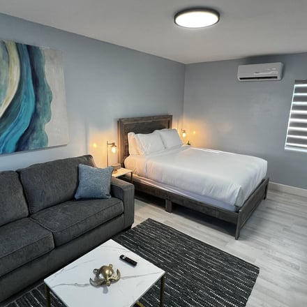 Spacious suite with sofa, bed and ocean-inspired artwork
