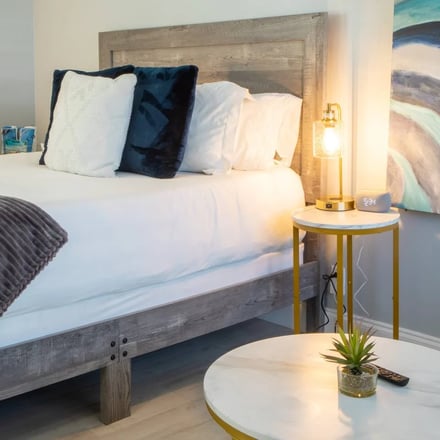 King suite with bedside lamps and ocean-wave artwork
