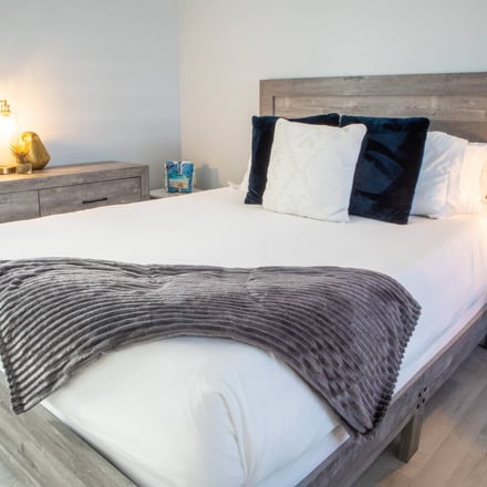 King bed with plush pillows and warm lighting