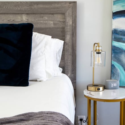 Bedside detail with lamp and ocean-wave artwork